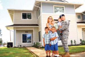 Smiling family of veterans in front of their new home